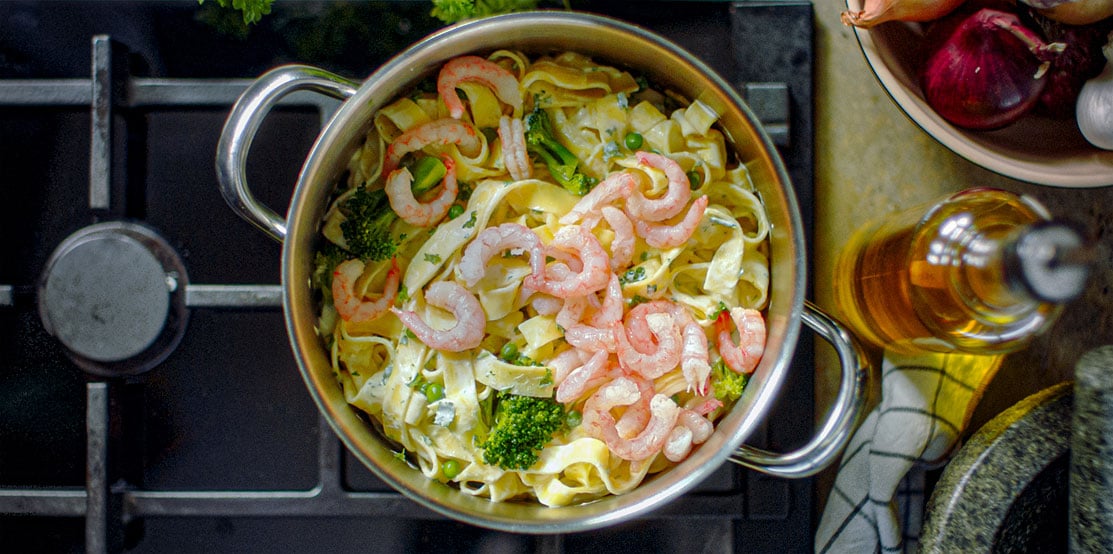 Creamy pasta with peas, broccoli and prawns