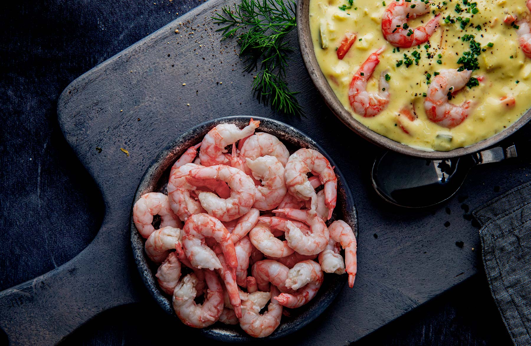 Prawns in a bowl next to prawn soup
